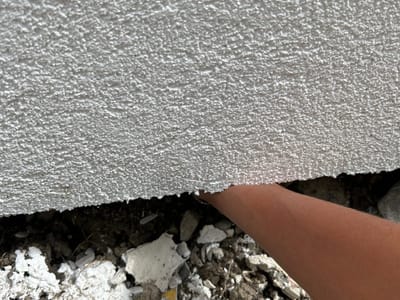 External wall insulation stopping short of finished ground level, leaving the cavity open