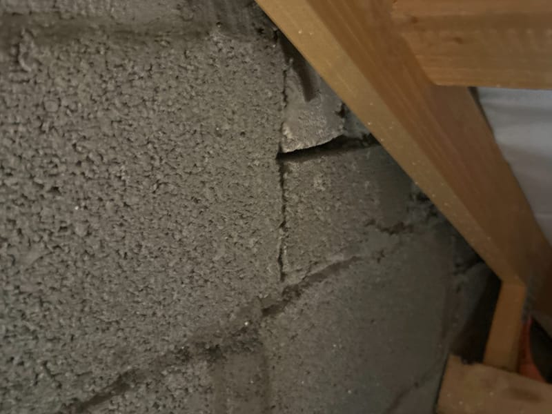Cracked blockwork at a party wall, photographed during an inspection