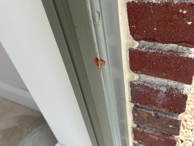 Sealant bead broken at the reveal — Door reveal