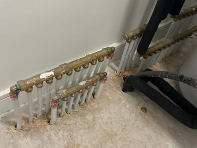 Underfloor heating manifold left unfixed — Utility